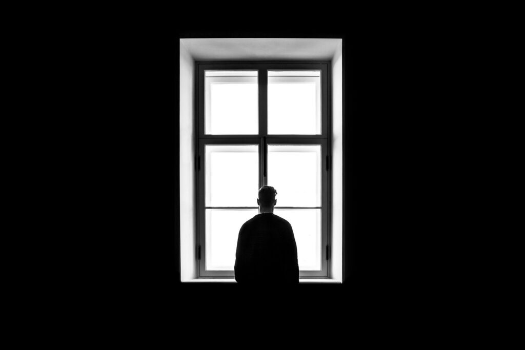 depressed man looking out of window