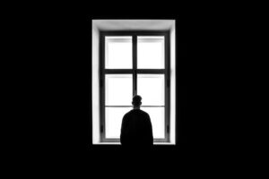 depressed man looking out of window