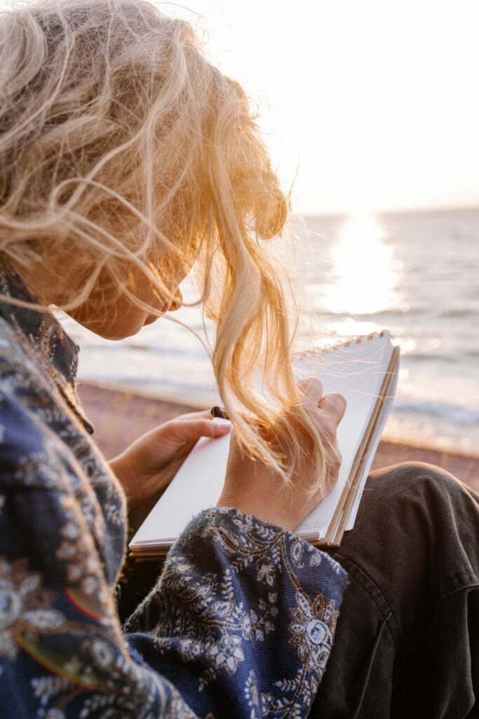 woman writing on beach