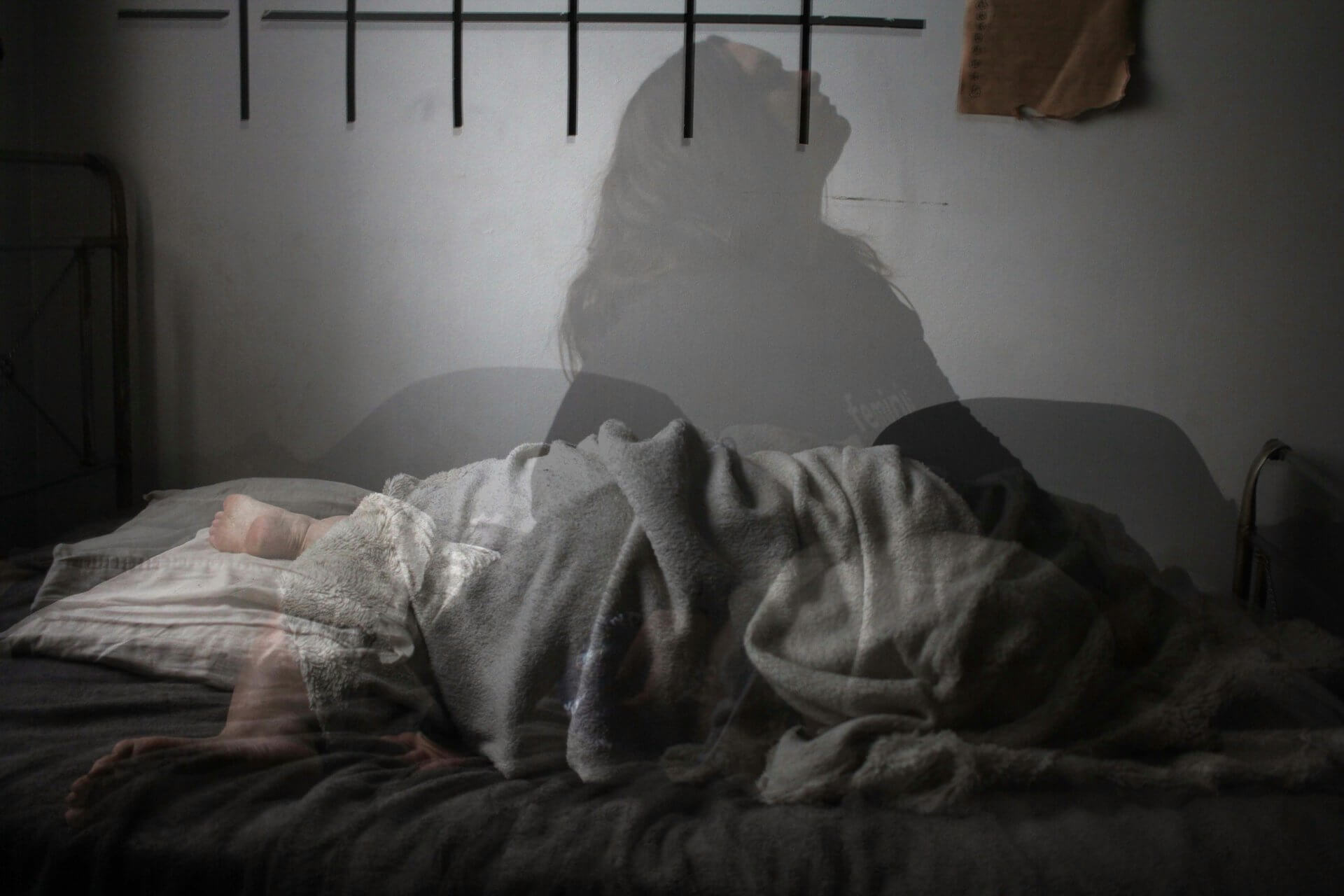 women sleeping with her shadow appearing on the wall